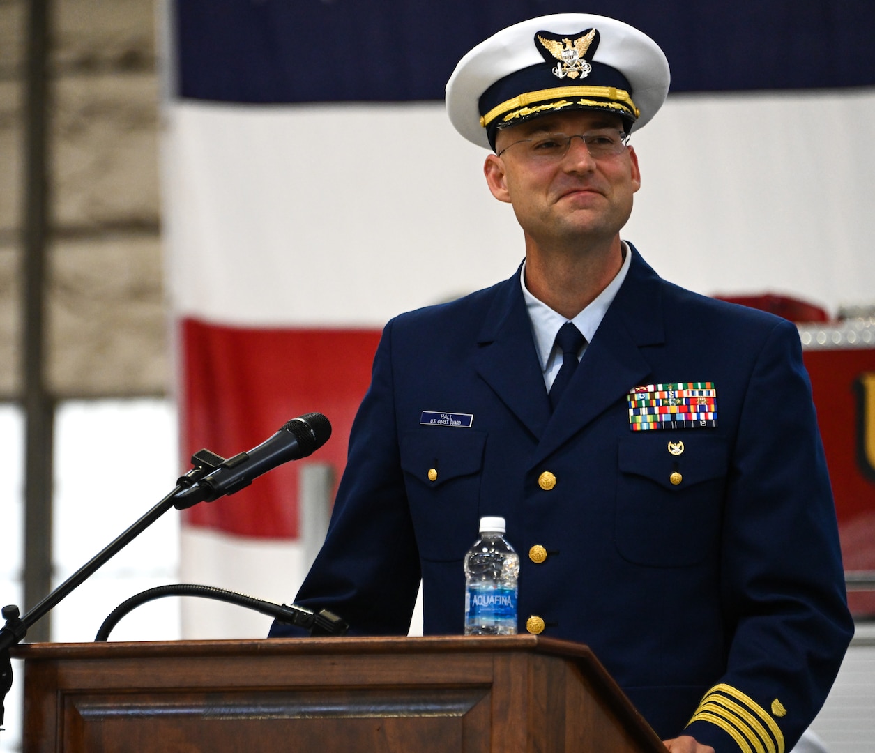 U.S. Coast Guard Capt. Jeremey Hall addresses Base Kodiak crew members as the oncoming commanding officer during a change-of-command ceremony at Air Station Kodiak, June 6, 2023. The change-of-command ceremony is a historic Coast Guard and Naval tradition, which has remained unchanged for centuries and includes the reading of the command orders in the presence of all unit crewmembers. U.S. Coast Guard photo by Petty Officer 3rd Class Ian Gray.