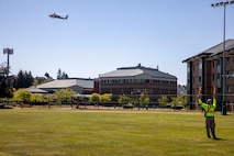 Mike Koegal, an operations leader for King County Search and Rescue, directs an MH-60 Seahawk helicopter, assigned to Naval Air Station Whidbey Island's Search and Rescue, to land at Naval Station Everett (NSE), June 6, 2023. NSE participated in a regional aircraft emergency response training exercise that includes aircraft and first responders from state, county, and local partner agencies in the Northwest Regional Aviation consortium. The training focuses on preparing for a potential real-world earthquake and tsunami disaster response. The exercise will help participating organizations, including the Navy, improve their ability to work together to support local emergency responders in a large-scale organized response. (U.S. Navy photo by Mass Communication Specialist 2nd Class Ethan Soto)