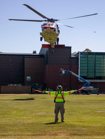 Mike Koegal, an operations leader for King County Search and Rescue, directs an MH-60 Seahawk helicopter, assigned to Naval Air Station Whidbey Island's Search and Rescue, to land at Naval Station Everett (NSE), June 6, 2023. NSE participated in a regional aircraft emergency response training exercise that includes aircraft and first responders from state, county, and local partner agencies in the Northwest Regional Aviation consortium. The training focuses on preparing for a potential real-world earthquake and tsunami disaster response. The exercise will help participating organizations, including the Navy, improve their ability to work together to support local emergency responders in a large-scale organized response. (U.S. Navy photo by Mass Communication Specialist 2nd Class Ethan Soto)