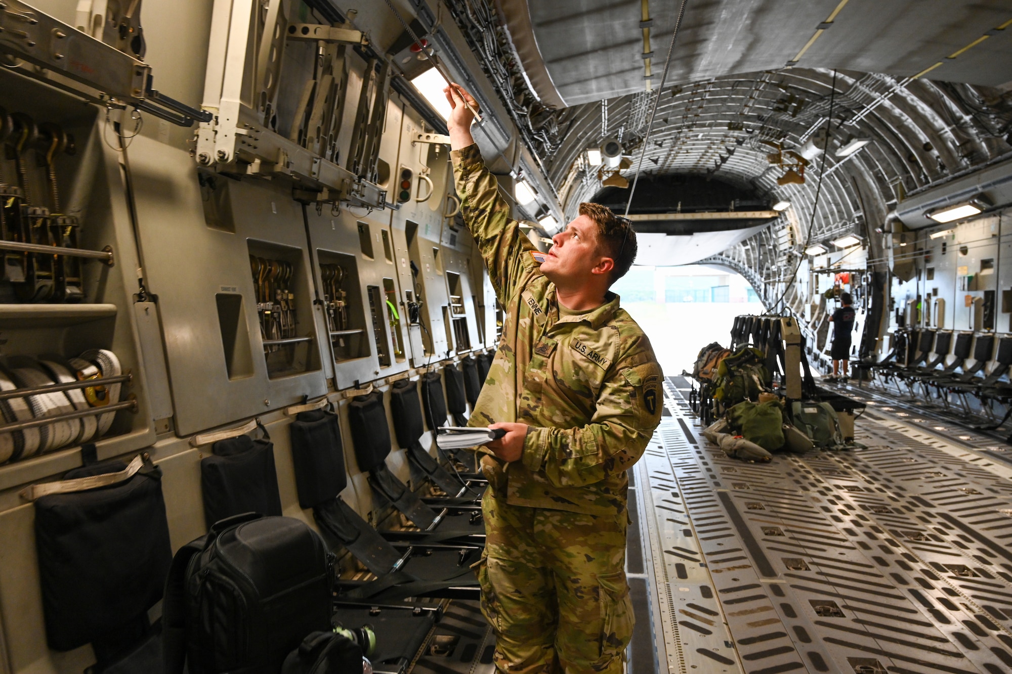 U.S. Army Staff Sgt. Logan Yenne, 1st Battalion (Airborne) 143rd infantry training noncommissioned officer in charge, checks the integrity of a static line at Fort Cavazos, Texas, June 2, 2023. Staff Sgt. Yenne ensured the static lines were free of breaks and connected properly to prevent malfunctions during air drops. (U.S. Air Force photo by Airman 1st Class Miyah Gray)