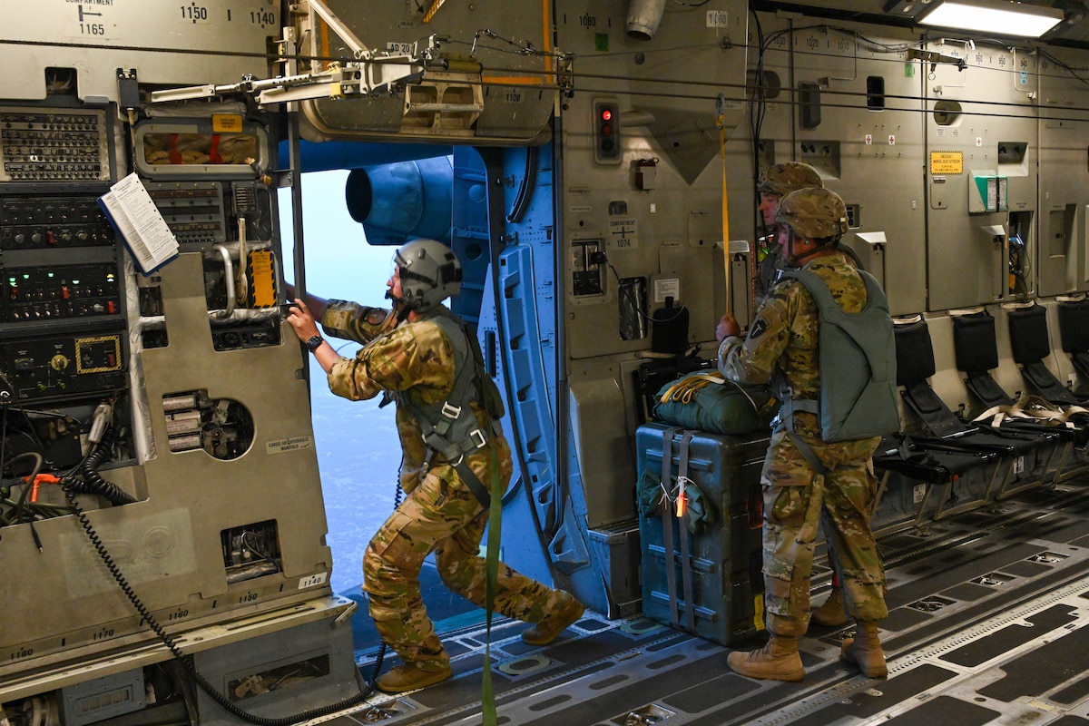 U.S. Air Force Tech. Sgt. Carter Raines, 58th Airlift Squadron instructor loadmaster, in spects the left paratrooper door of a C-17 Globemaster III before a static line jump at Fort Cavazos, Texas, June 2, 2023. Tech Sgt. Raines ensured passengers and cargo were safely secured on the aircraft during flight and while performing airdrops. (U.S. Air Force photo by Airman 1stClass Miyah Gray)