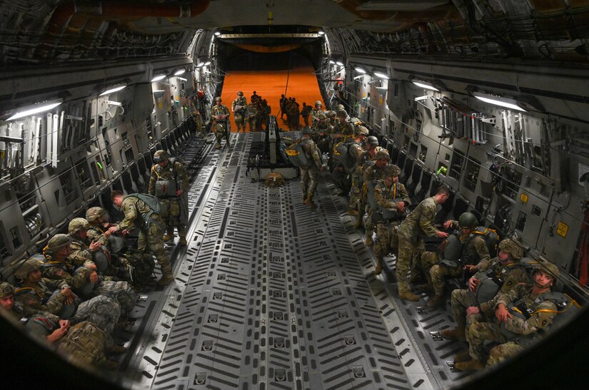 Soldiers load an aircraft in the dark.