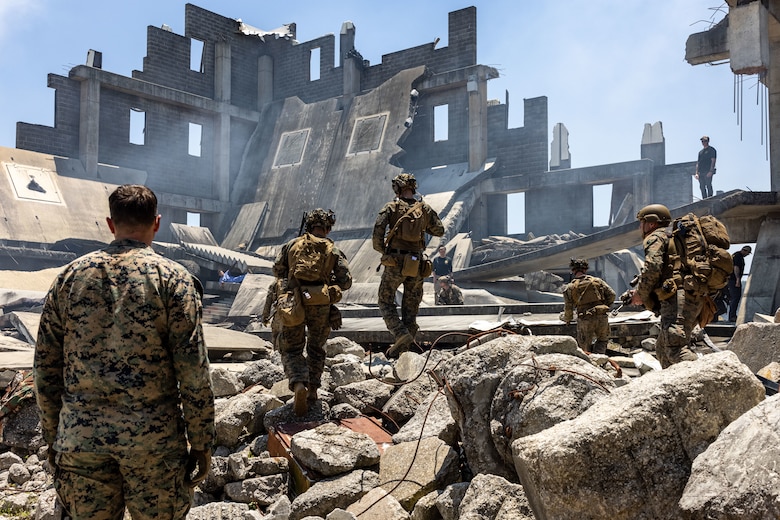 U.S. Marines with the 26th Marine Expeditionary Unit (MEU) search for casualties in a collapsed building after a notional aftershock during a simulated foreign humanitarian assistance (FHA)  during Composite Training Unit Exercise in Perry, Georgia, May 27, 2023. FHA consists of Department of Defense activities conducted outside of the U.S. and its territories to directly relieve or reduce human suffering, disease, hunger, or privation. FHA is intended to supplement or complement efforts of host nation civil authorities or agencies with the primary responsibility for providing assistance. The 26th Marine Expeditionary Unit serves as one of the Nation’s premier crisis response forces capable of conducting amphibious operations, crisis response, and limited contingency operations, to include enabling follow-on forces and special operations.