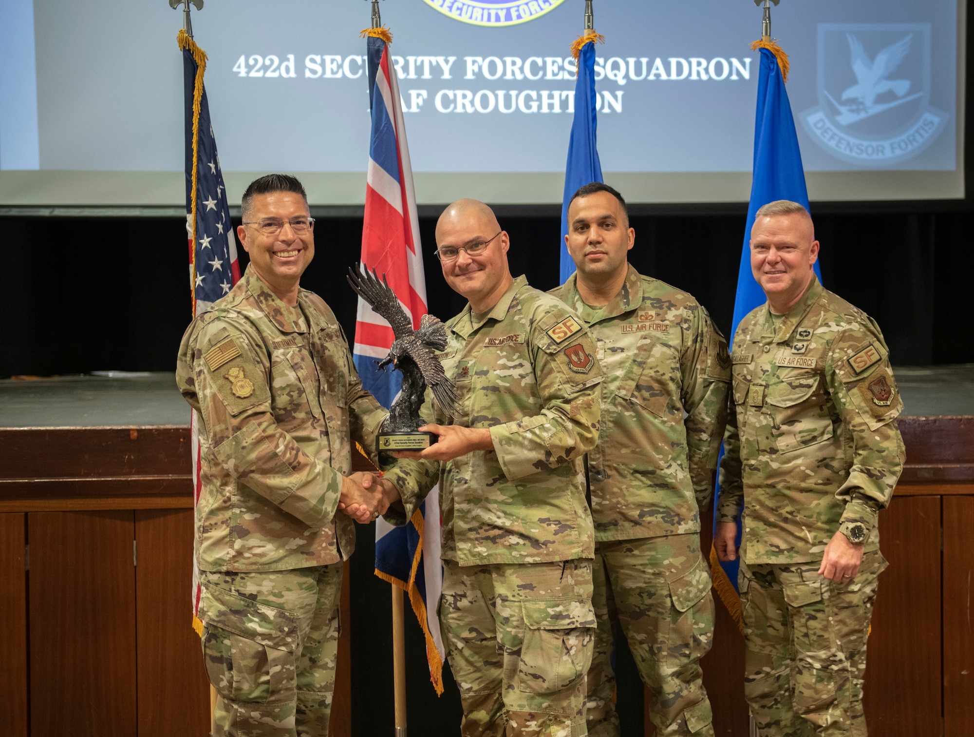 Brig. Gen. Thomas Sherman, United States Air Force director of security forces, left, presents 422d Security Forces Squadron leadership the award for being the best small security forces squadron in the USAF