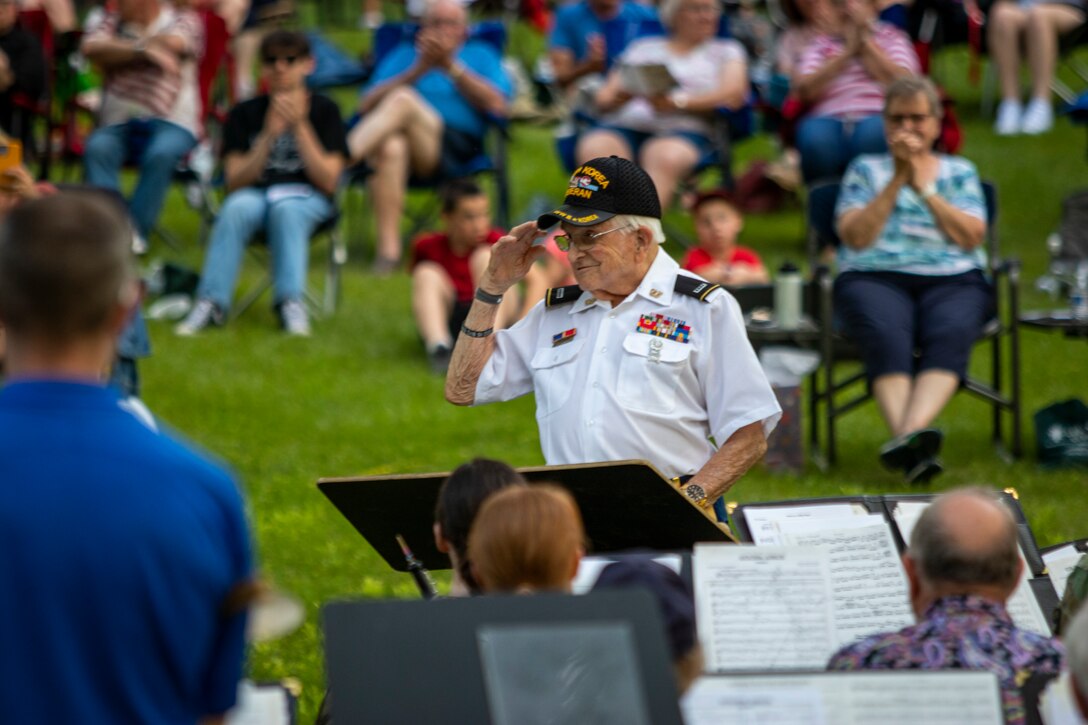 Retired Chief Warrant Officer 4 William Splichal, 99-years-old, conducts the Nebraska National Guard's 43rd Army Band Soldiers and alumni through John Philip Sousa's Golden Jubilee, during a 75th anniversary concert, June 3, 2023, at the Wildewood Park in Ralston, Nebraska.