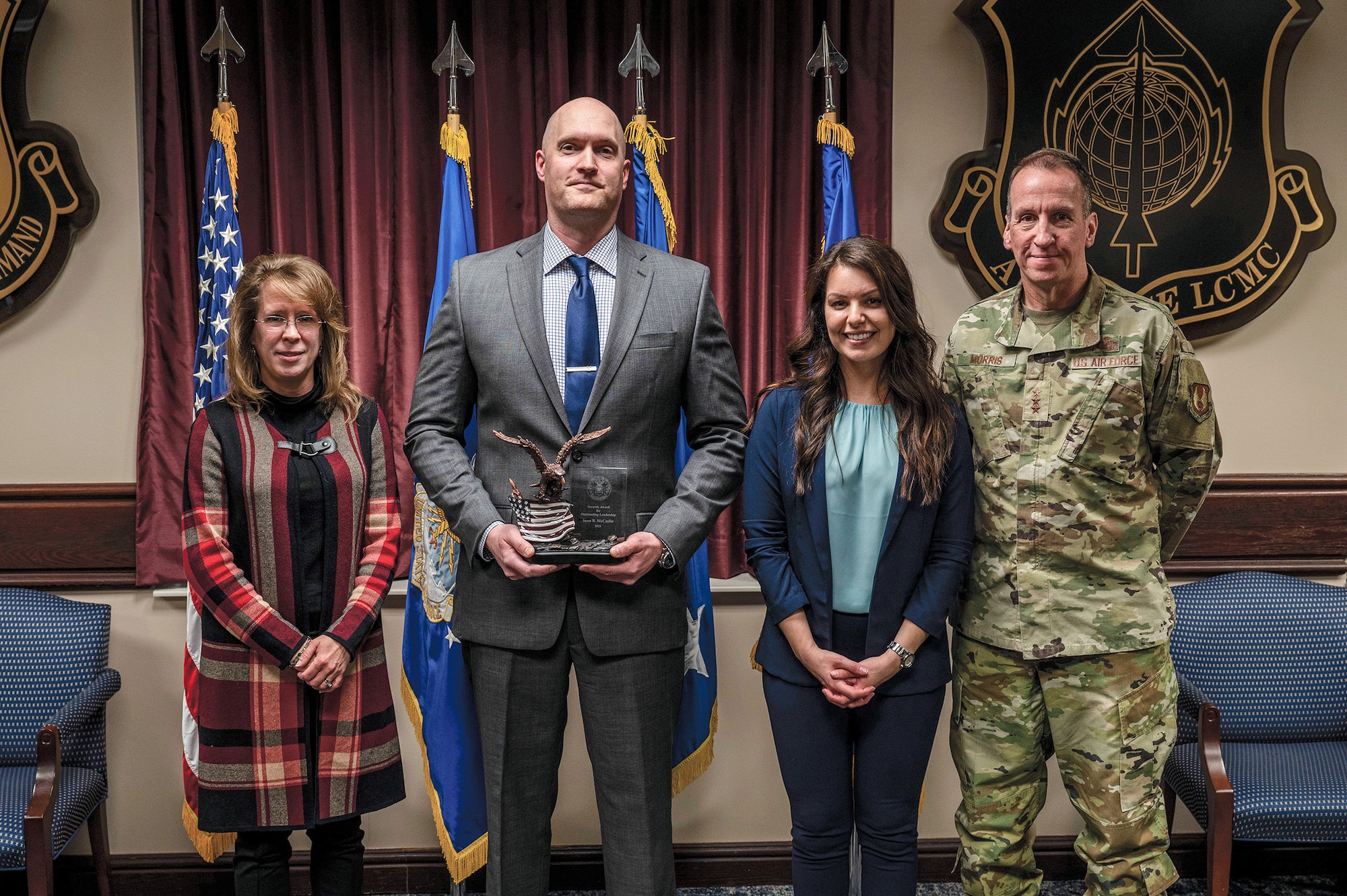 Sean McCaslin, Air Force Life Cycle Management Center Special Access Programs Oversight chief of security, takes a photo with his wife, Annie McCaslin; Jennifer M. Aquinas, left, Director of Security, Special Program Oversight and Information Protection, Office of the Administrative Assistant, Office of the Secretary of the Air Force in Arlington, Virginia; and Lt. Gen. Shaun Q. Morris, AFLCMC commander, after being presented the 2021 Air Force Security Community Award for Outstanding Leadership for his civilian job, March 27, 2023. McCaslin is a senior master sergeant assigned to the 445th Security Forces Squadron as a traditional Air Force reservist.