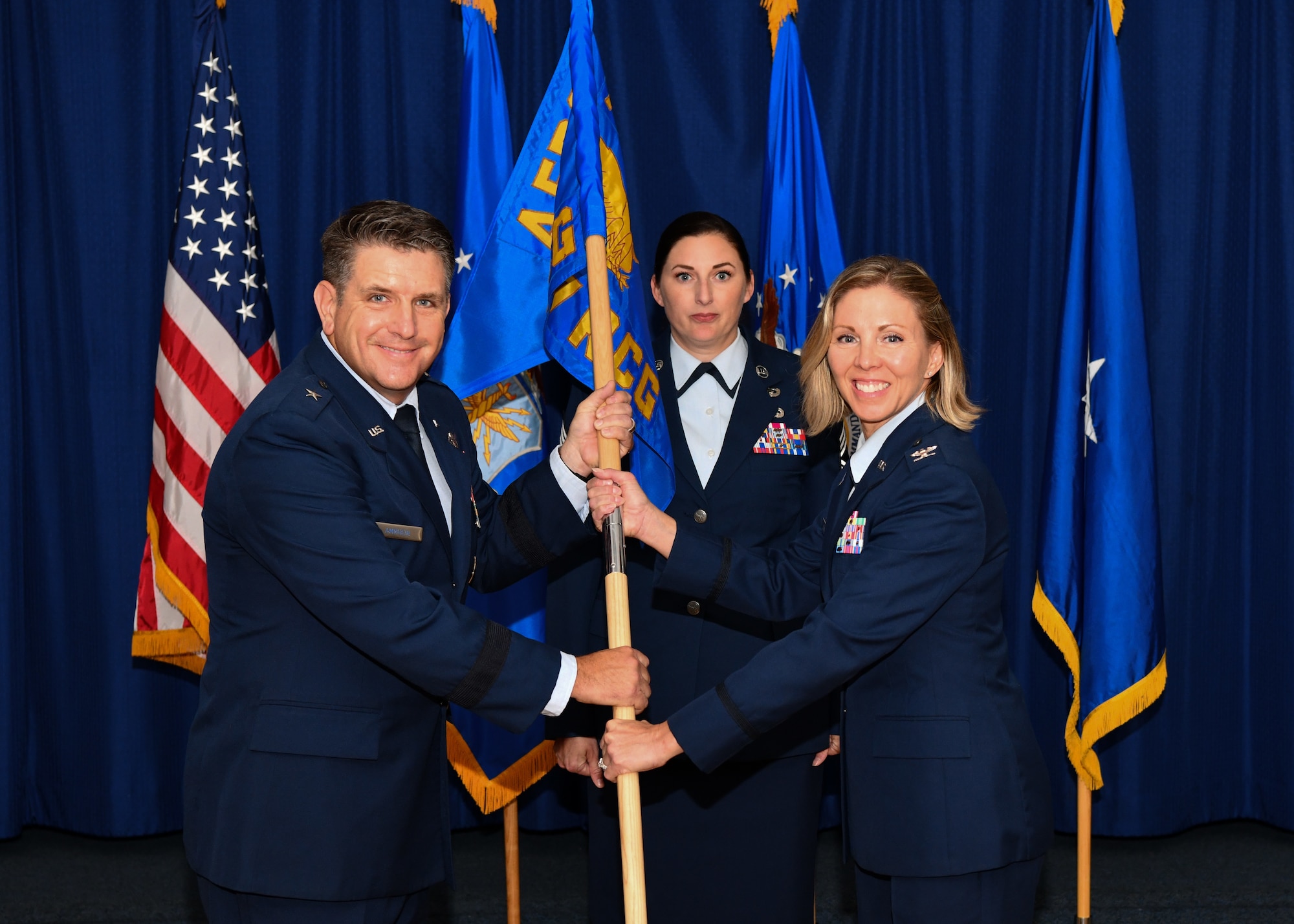Air Force Recruiting leadership pose with a guidon during an assumption of command ceremony