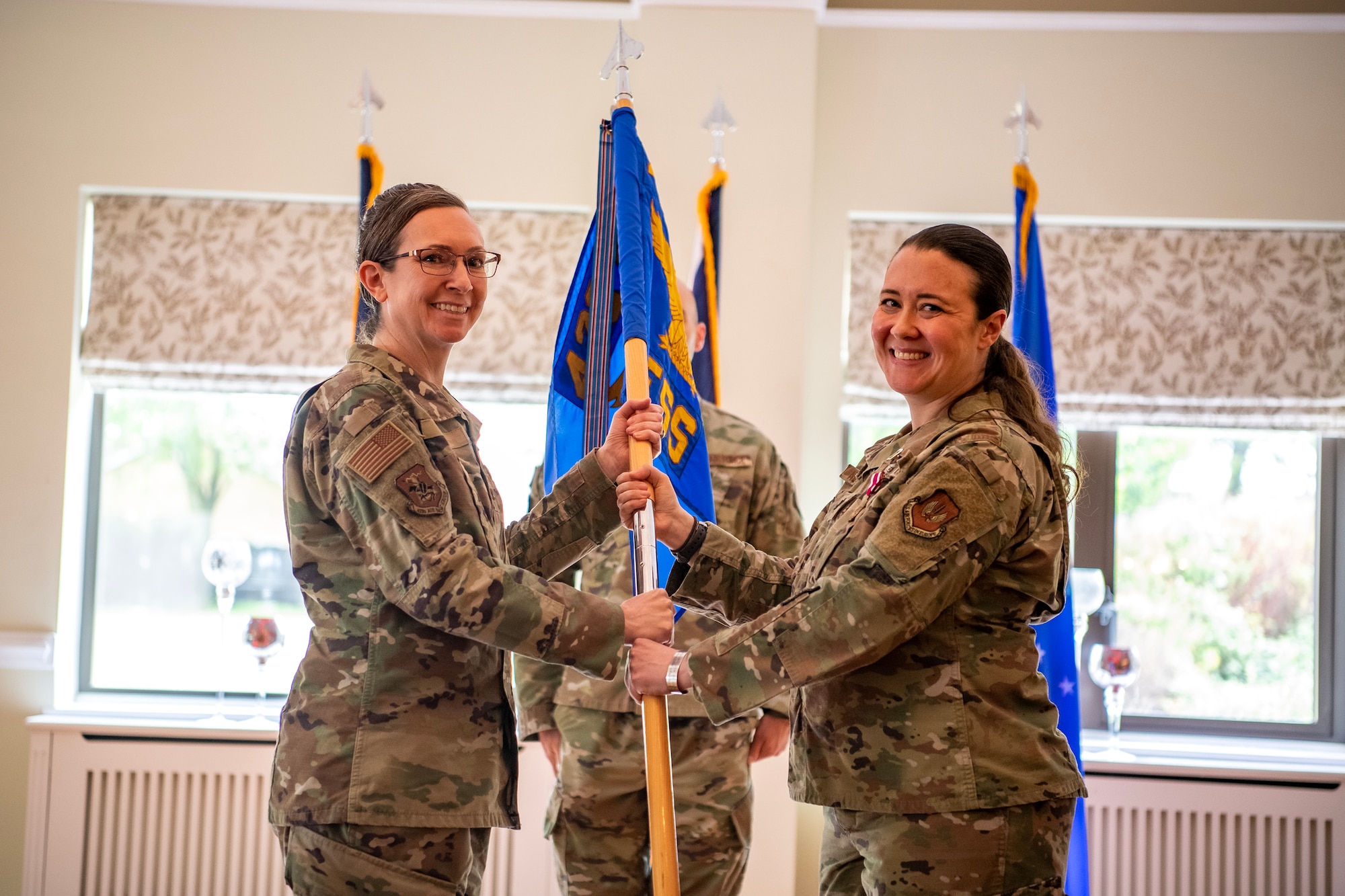 U.S. Air Force Col. Valarie Long, left, 423d Air Base Group commander, receives the 423d Force Support Squadron guidon from Lt. Col. Kirsten Nicholls, 423d FSS outgoing commander, during a change of command ceremony at RAF Alconbury, England, June 5, 2023. During her command, Nicholls implemented quality of life programs for 32 facilities across two installations. Her activities also served 12 joint force and multi-national mission partners. (U.S. Air Force photo by Staff Sgt. Eugene Oliver)