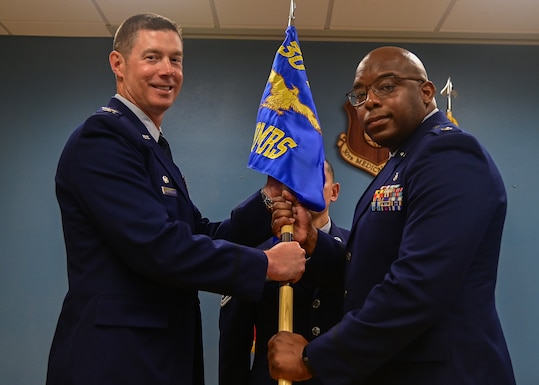 U.S. Air Force Col. Brent Cunningham, 30th Medical Group commander, passes the 30th Operational Medical Readiness Squadron flag to U.S. Air Force Lt. Col. Marcus Boone, incoming 30th OMRS commander, during a change of command ceremony on Vandenberg Space Force Base, Calif., June 6, 2023. Boone took Lt. Col. Cervantes' place as the 30th OMRS commander. (U.S. Space Force photo by Airman 1st Class Ryan Quijas)