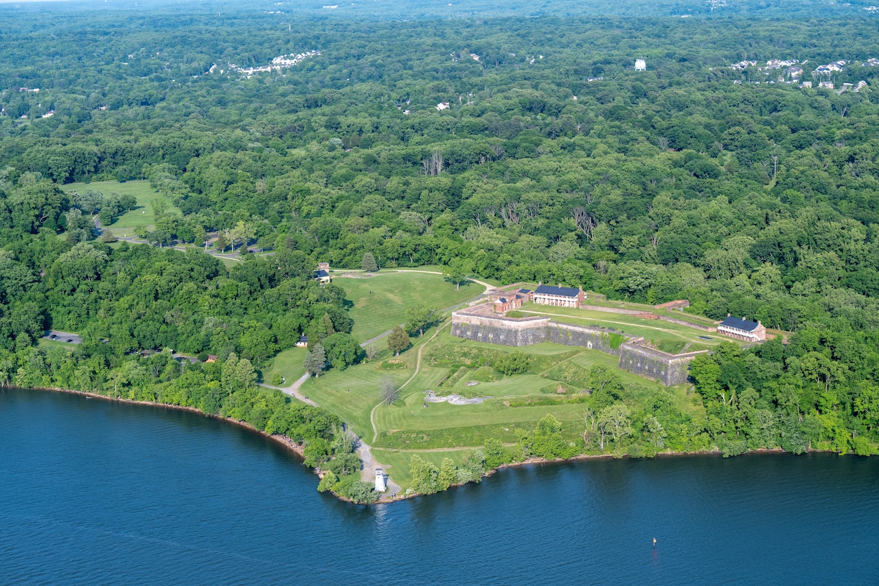 An aerial view of an old fort’s fortified walls surrounded by grass and trees.