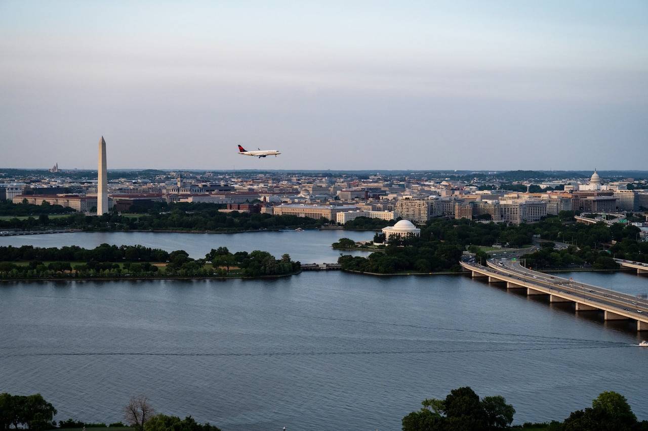 An aerial view of an airplane flying above Washington, D.C. Nearby is the Washington Monument.
