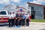 EMS personnel standing in front of ambulance.