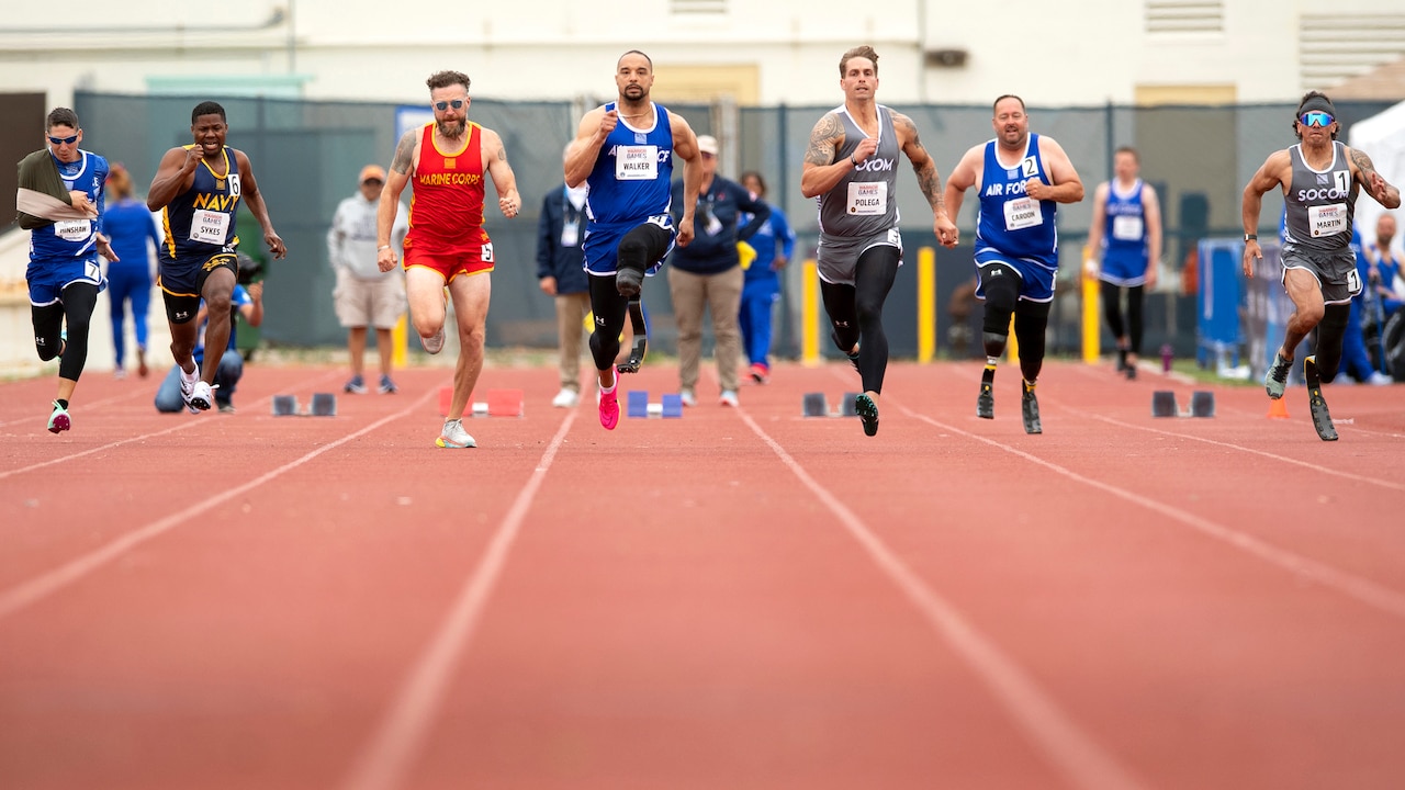 Services members spring on a track.