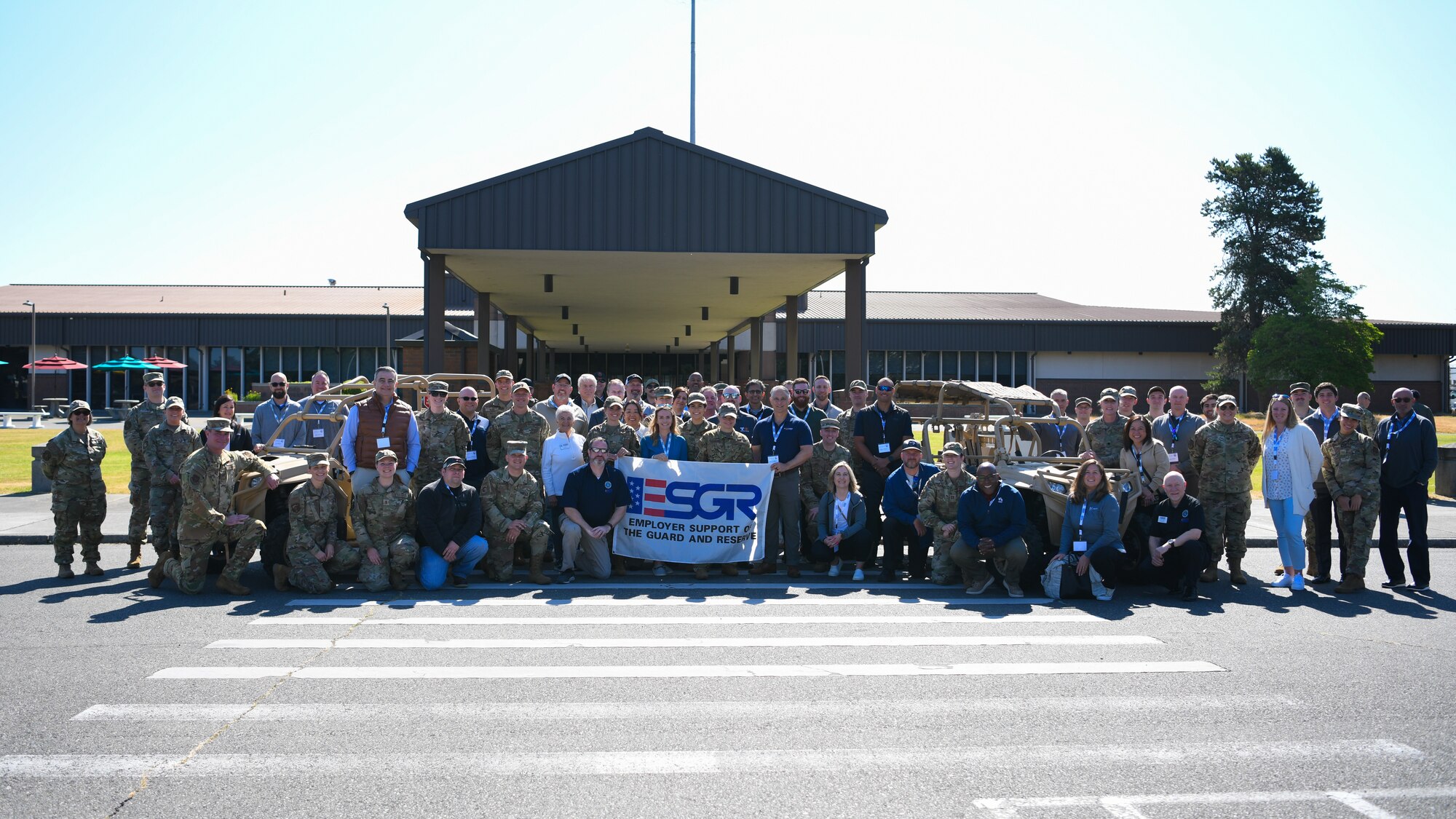 A group photo of civilians and Reservists in front of a building.