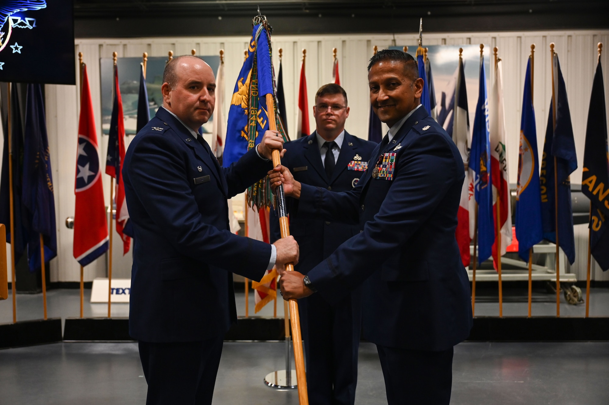 U.S. Air Force Lt. Col. Ajay K. Giri, 16th Electronic Warfare Squadron (EWS) outgoing commander, right, passes the guidon to U.S. Air Force Col. Robert P. Cocke, 350th Spectrum Warfare Group commander, left, at Eglin Air Force Base, June 6, 2023. The mission of the 16th EWS is to develop, test, validate, and field electromagnetic warfare capabilities for the warfighter. These capabilities enhance the survivability of our combat air forces in contested environments. (U.S. Air Force photo by Staff Sgt. Ericka A. Woolever)