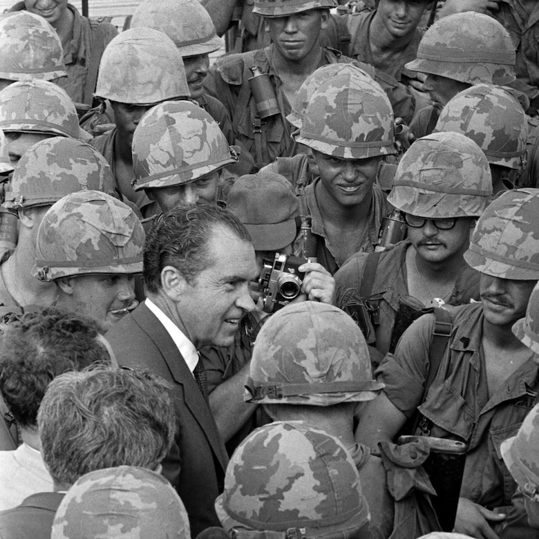 President Richard Nixon speaks to a crowd of soldiers in uniform.
