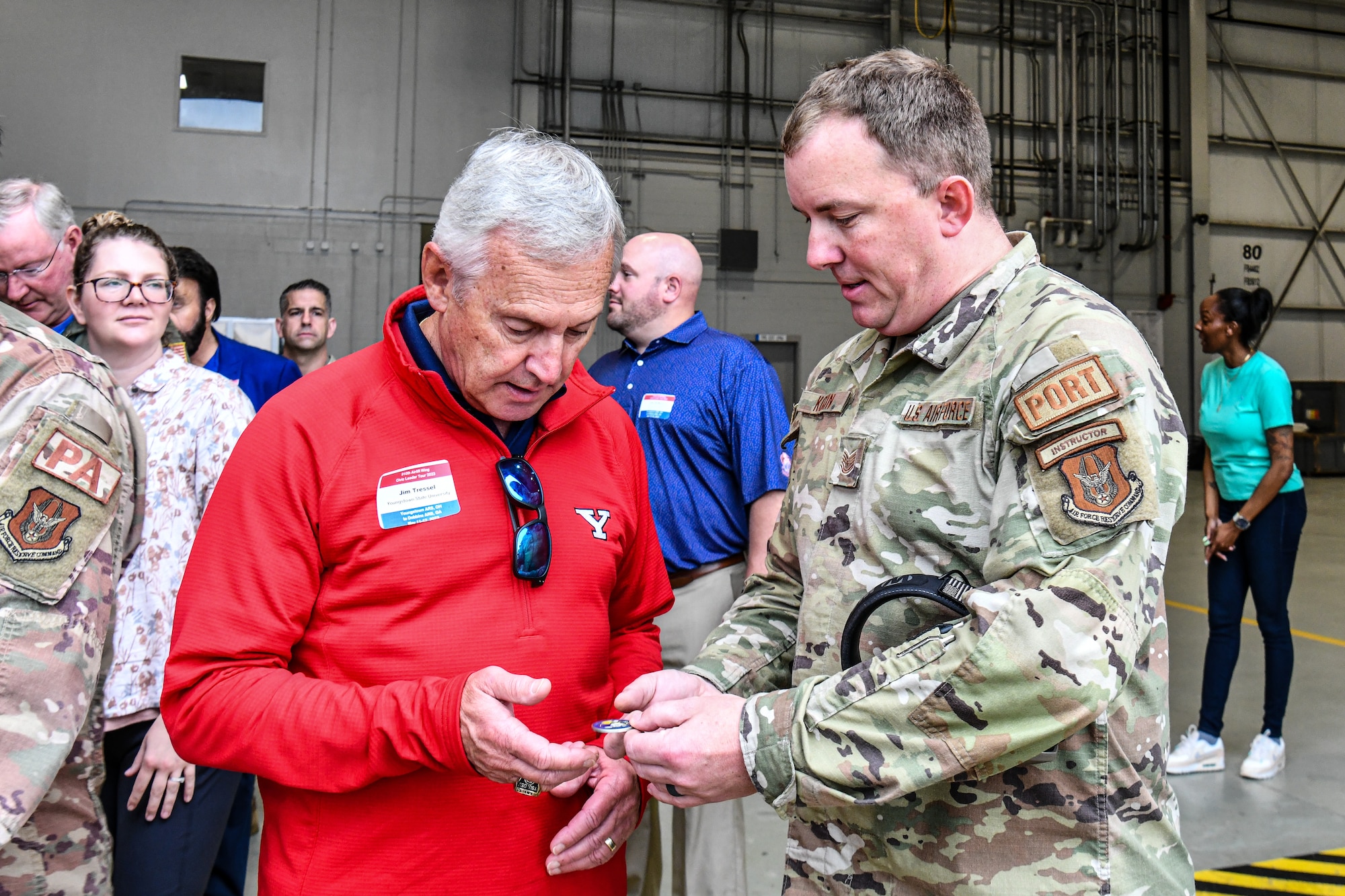 Tech. Sgt. Thomas Kocin, an air transportation instructor assigned to the 622nd Transportation Proficiency Center, presents a challenge coin to Jim Tressel, honorary commander of the 910th Airlift Wing and participant in the 910th AW’s civic leader tour to Dobbins Air Reserve Base, Georgia, May 12, 2023.