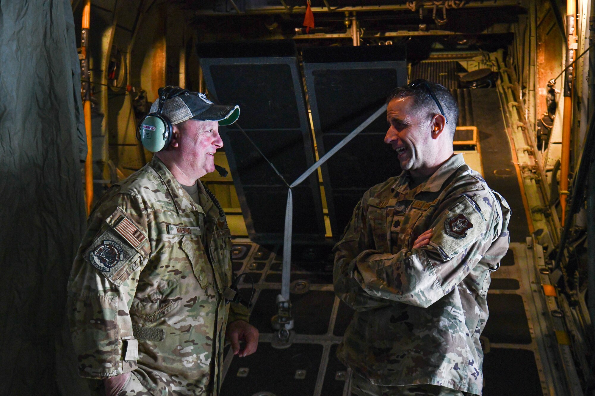 Chief Master Sgt. Christopher Marino, chief loadmaster assigned to the 757th Airlift Squadron, and Lt. Col. Scott Julian, 910th Airlift Wing executive officer, share a laugh on a C-130H Hercules aircraft during the flight to Dobbins Air Reserve Base, May 11, 2023.