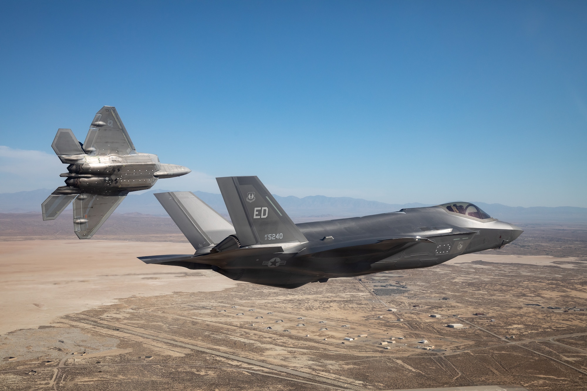 Two F-35s from the 461st Flight Test Squadron fly in the skies above Edwards Air Force Base. The squadron recently took flight with a complement of software applications developed by government and industry providers previously tested on the F-22 – demonstrating for the first time the ability to use the same tactical software applications on both stealth fighters. (U.S. Air Force Photo by Kyle Larson)