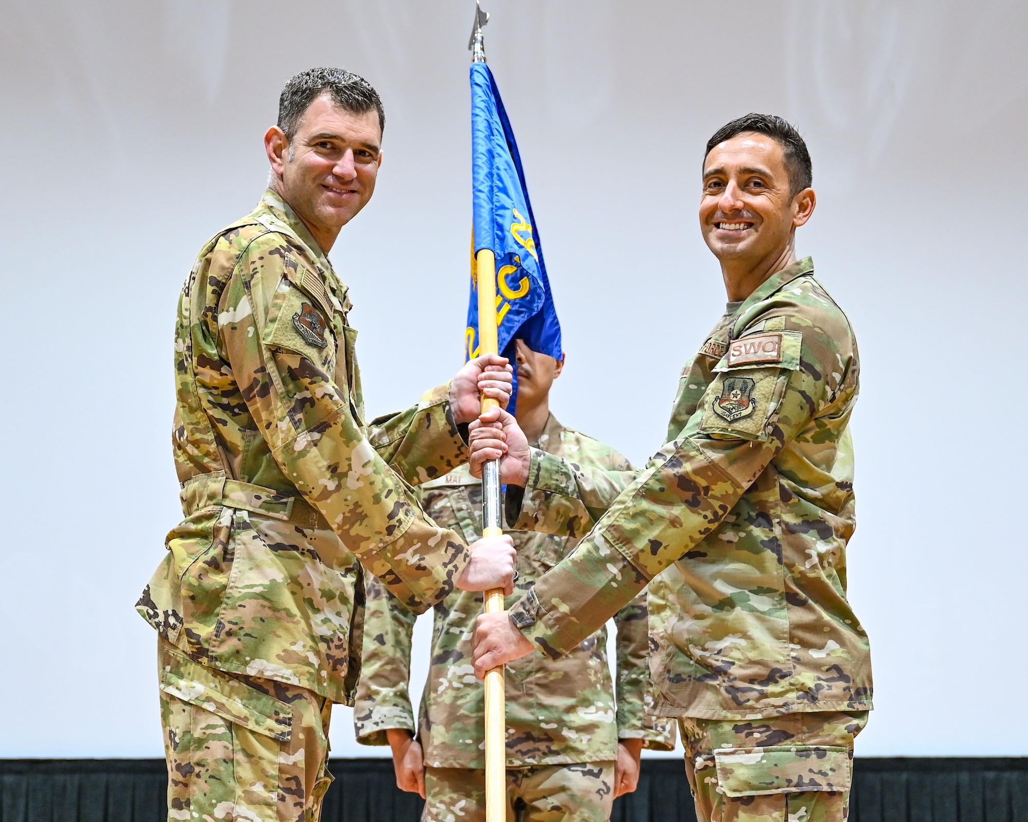 Col. Jeremy Ponn, 387th Air Expeditionary Group commander, passes the guidon to Lt. Col. Kyle Palmer, incoming 22nd Expeditionary Combat Weather Squadron commander, during a change of command ceremony at Ali Al Salem Air Base, Kuwait, June 7, 2023. The passing of the guidon symbolizes the passing of command from one commander to the next. (U.S. Air Force photo by Staff Sgt. Breanna Diaz)