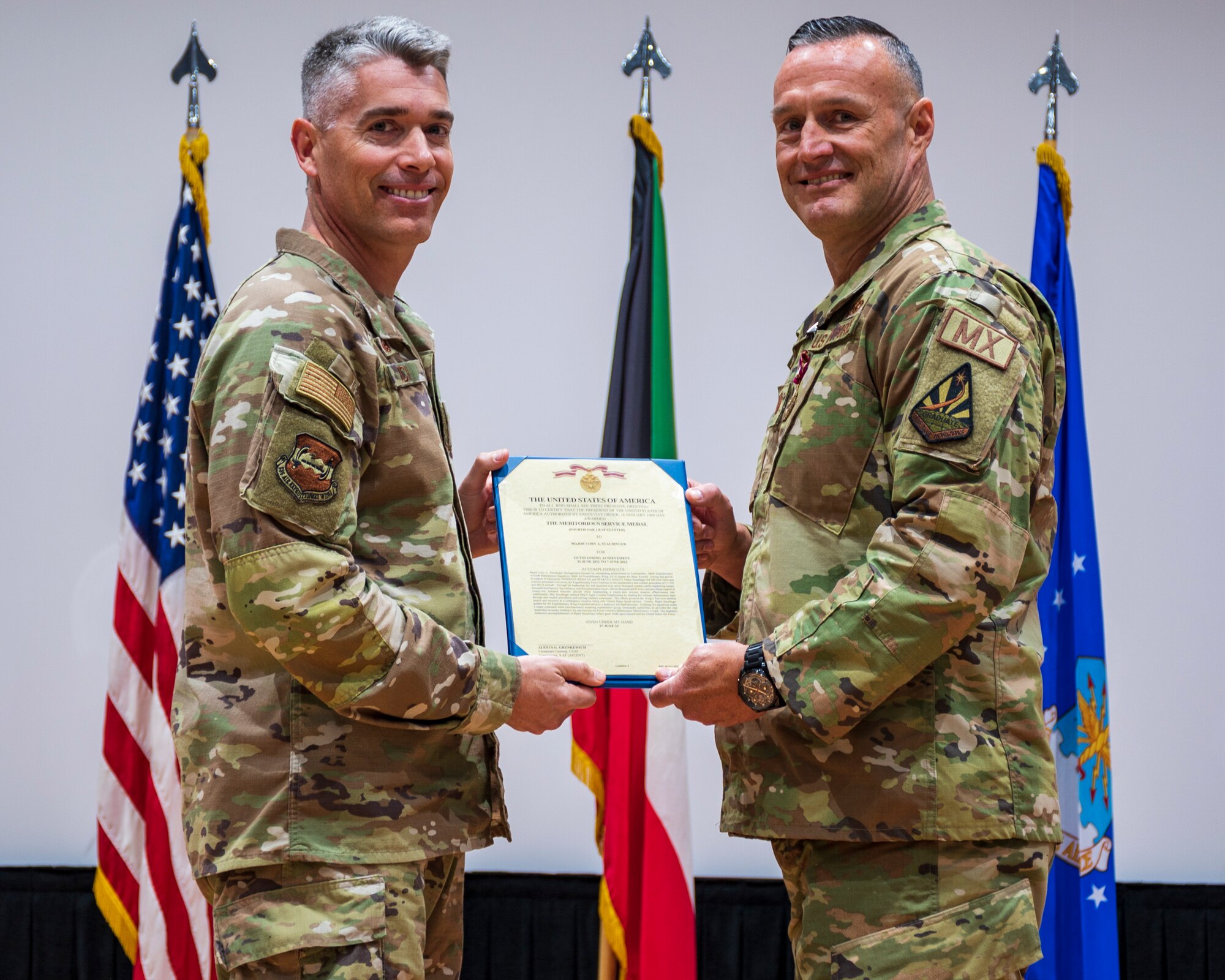 Col. George Buch, 386th Air Expeditionary Wing commander, presents a Meritorious Service Medal to Maj. Cory Staudinger.