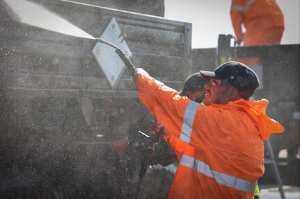 A contractor with the United States Army decontaminates and washes an M1078 cargo truck with a power washer so it can be further transported out of Adazi, Latvia, on May 19, 2023. DEFENDER 23 is a U.S. Army Europe and Africa led exercise focused on the strategic deployment of continental United States-based forces, employment of Army Prepositioned Stocks, and interoperability with Allies and partners.