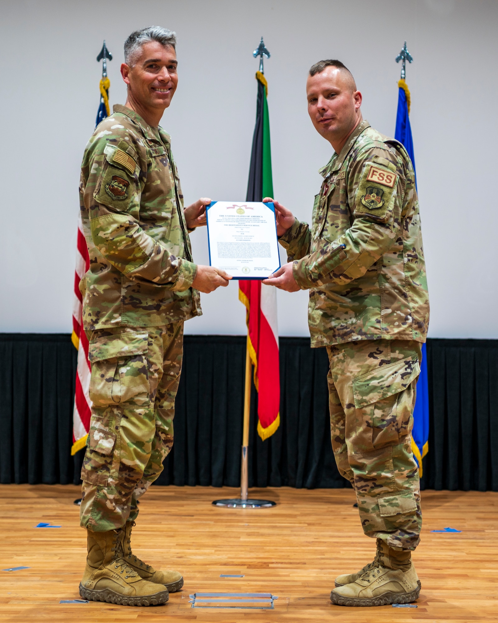 Col. George Buch, Jr., 386th Air Expeditionary Wing commander, presents a Meritorious Service Medal to Maj. Ryan Curran, outgoing 386th Expeditionary Force Support Squadron commander, during a change of command ceremony at Ali Al Salem Air Base, Kuwait, June 8, 2023