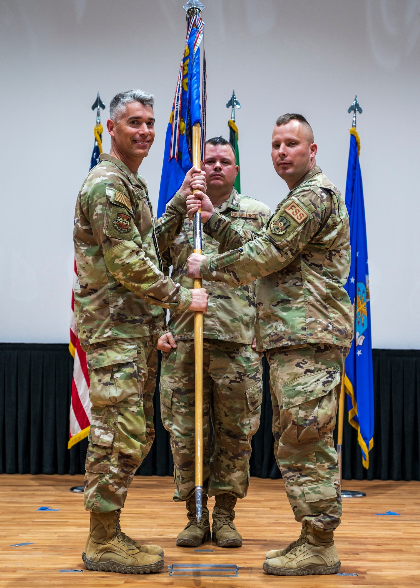Maj. Ryan Curran, outgoing 386th Expeditionary Aircraft Maintenance Squadron commander, passes the guidon to Col. George Buch, 386th Air Expeditionary Wing commander, during a change of command ceremony at Ali Al Salem Air Base, Kuwait, June 8, 2023