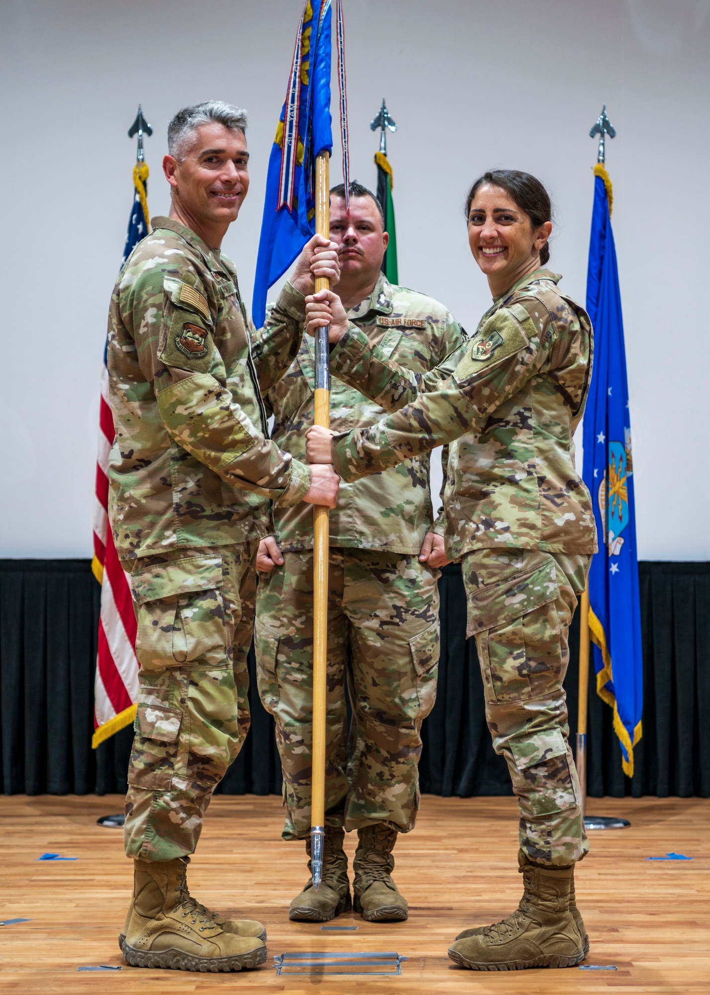 Col. George Buch, 386th Air Expeditionary Wing commander, passes the guidon to Maj. Katie Evans, incoming 386th EFSS commander, during a change of command ceremony at Ali Al Salem Air Base, Kuwait, June 8, 2023.