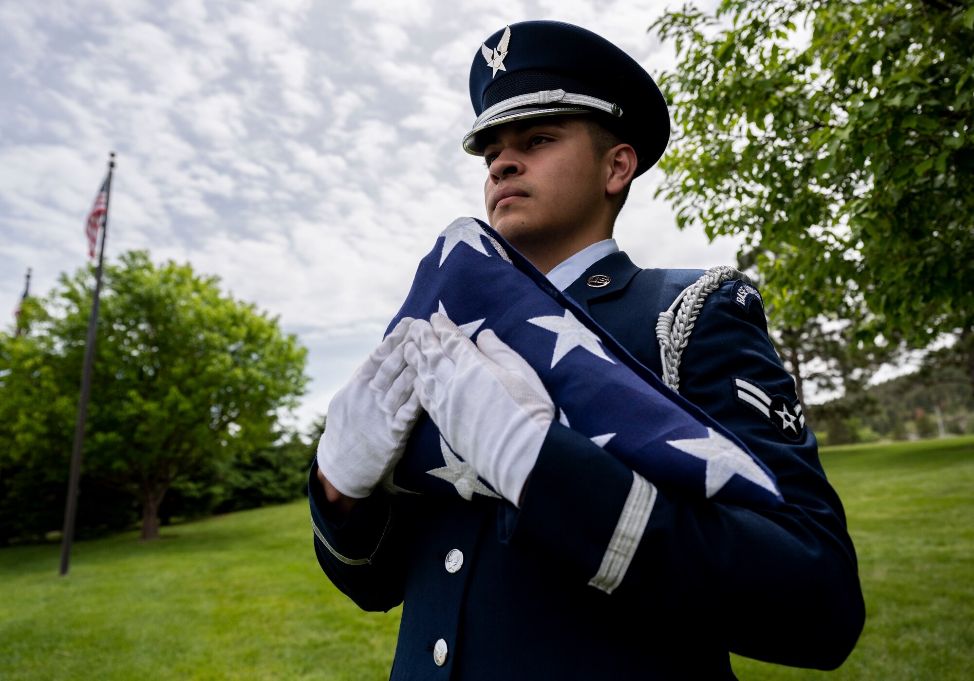 Airman 1st Class Azrael Gamboa, 28th Force Support Squadron ceremonial guardsman, secures a flag before a funeral at Black Hills National Cemetery, South Dakota, June 1, 2023.