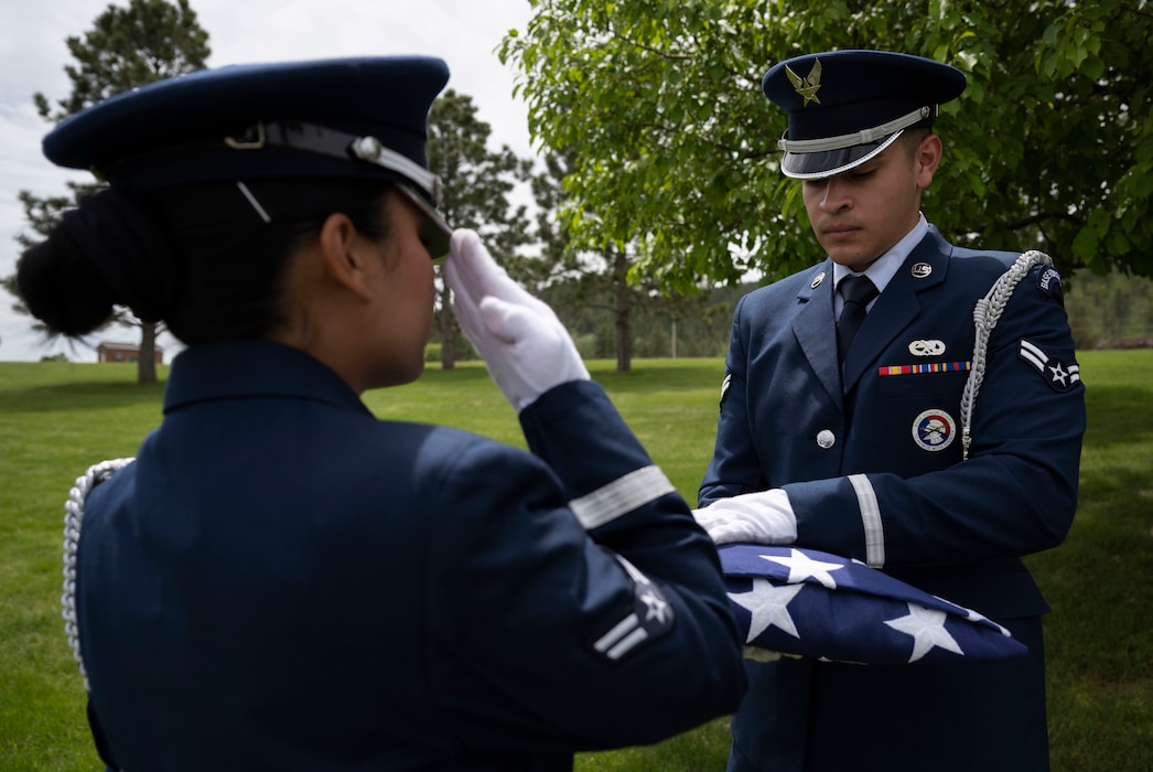 Airman 1st Class Mialani Mae Morgan, 28th Force Support Squadron ceremonial guardsman, salutes a flag at Black Hills National Cemetery, South Dakota, June 1, 2023.