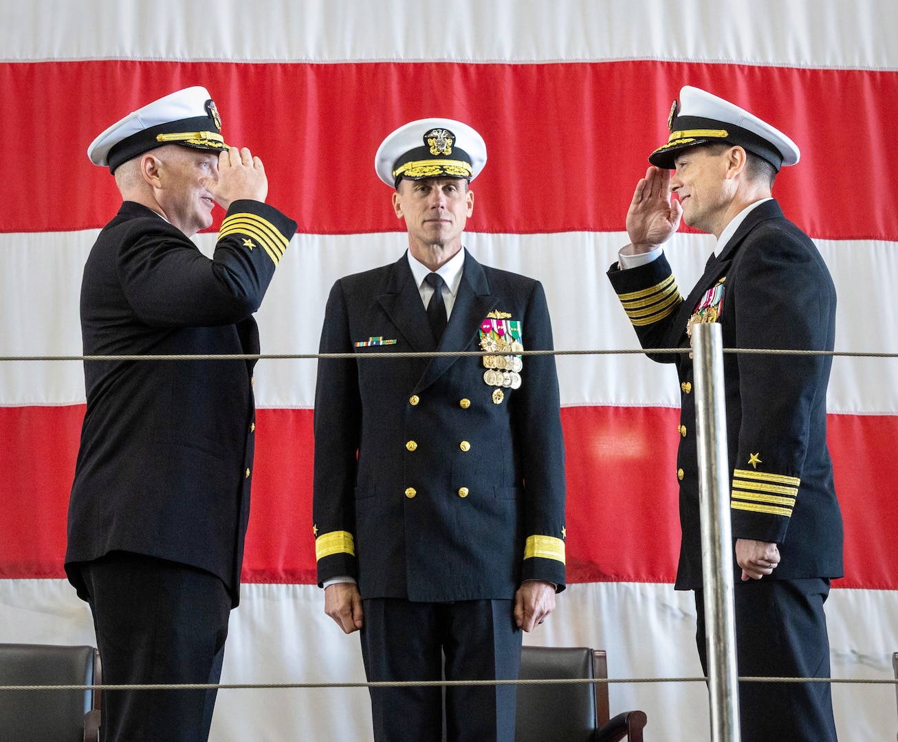 Capt. JD Crinklaw, right, became the 52nd commander of Puget Sound Naval Shipyard & Intermediate Maintenance Facility during a change-of-command ceremony May 25, 2023, in Building 460 at the shipyard in Bremerton, Washington. Crinklaw takes over for former commander Capt. Jip Mosman, left, who led PSNS & IMF since December 2020. Rear Adm. Scott Brown, center, deputy commander, Industrial Operations, Naval Sea Systems Command, presided over the ceremony. (U.S. Navy photo by Wendy Hallmark)