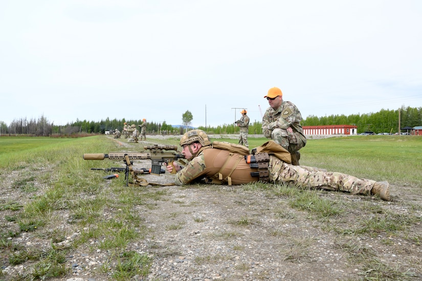 Alaska Army National Guard Staff Sgt. Travis Hall, 49th Missile Defense Battalion (GMD), fires a M110 A1 Marksman Rifle as AKARNG Maj. James Goddard, officer in charge of the TAG Match, acts as a range safety at the Fort Wainwright Range Complex June 4, 2023. The TAG Match is an annual marksmanship competition designed to challenge and test basic shooting fundamentals.