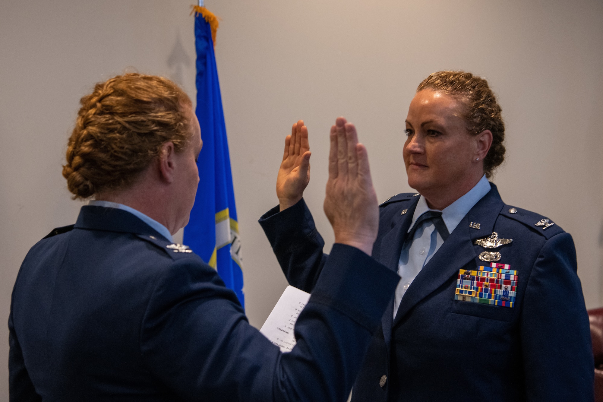 One military female issues the oath of office to her twin sister.