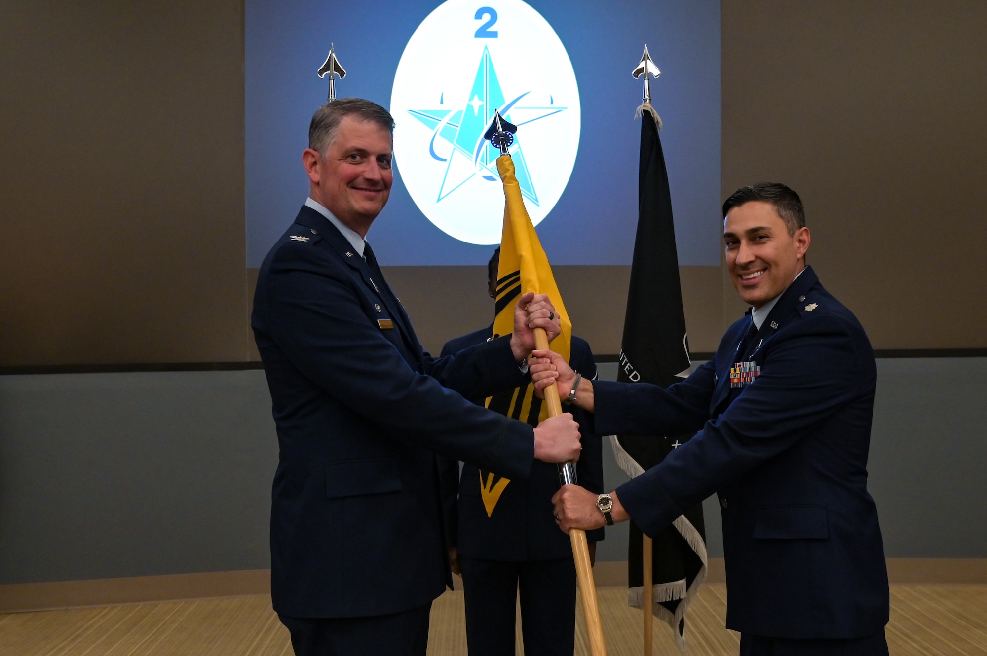 U.S. Space Force Col. Robert Long, Space Launch Delta 30 commander, hands over command from U.S. Space Force Force Lt. Col. Nicholas M. Somerman, outgoing 2nd Range Operations Squadron commander, to incoming commander U.S. Space Force Lt. Col. Darin J. Lister at the 533rd Training Squadron auditorium on Vandenberg Space Force Base, Calif., June 8, 2023. (U.S. Space Force photo by Senior Airman Rocio Romo)