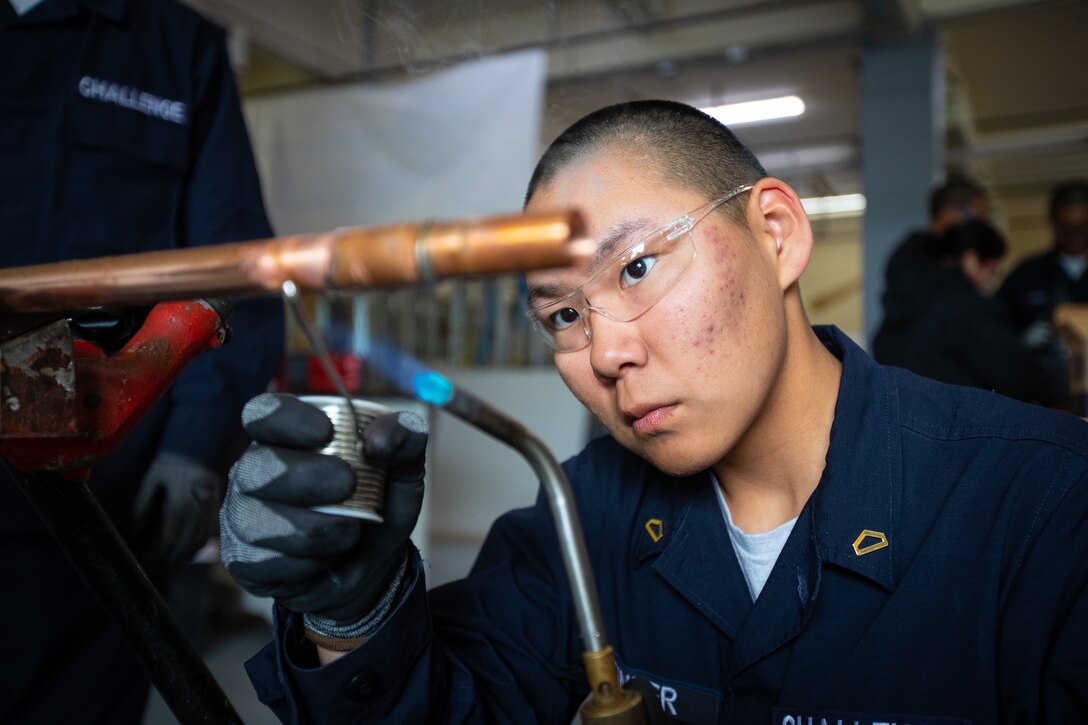 Alaska Military Youth Academy cadet Jackie Tinker uses a hand torch to solder a piece of copper pipe during a Career Work Experience program class at Alaska Works Partnership in Anchorage June 01, 2023.