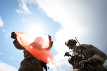 Tech. Sgt. Cameron Gumm, 841st Missile Security Forces Squadron squad leader, left, folds a visibility marker as Tech. Sgt. Daniel Reshef, 841st MSFS flight chief, stands by for the arrival of a U.S. Army UH-60 Black Hawk at Fort William Henry Harrison, Mont., May 31, 2023. The Montana National Guard joined the 841st MSFS for Operation Avalanche Defender, a four-day simulated deployment exercise.