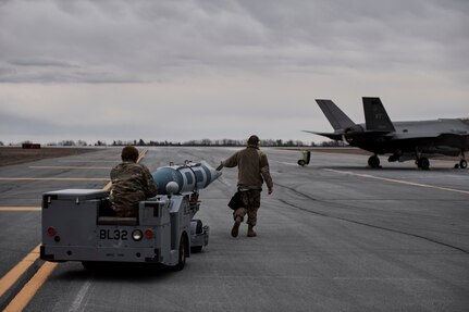 Photo of Airmen assigned to the Vermont Air National Guard's 158th Fighter Wing, from South Burlington, Vermont, loading inert 2,000 pound GBU-31 GPS guided bombs onto their F-35A Lightning II jets for a training mission at Wheeler-Sack Army Airfield , Fort Drum, New York, April 3, 2023.