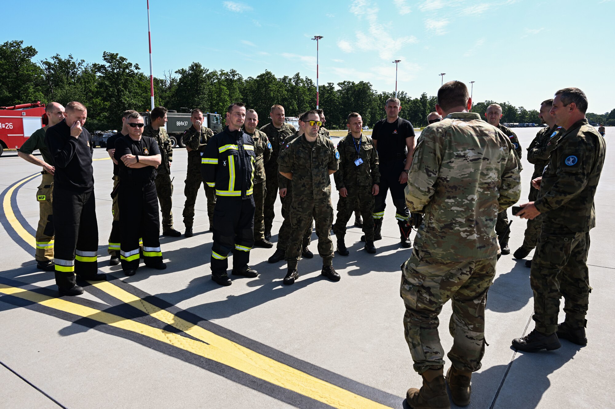 U.S. Air Force Tech. Sgt. Joshua Gorman, 480th Fighter Generation Squadron Crash, Damaged Disabled Aircraft Recovery (CDDAR) team chief, greets Polish fire department members with the 33rd Airlift Base at Powidz Air Base, Poland