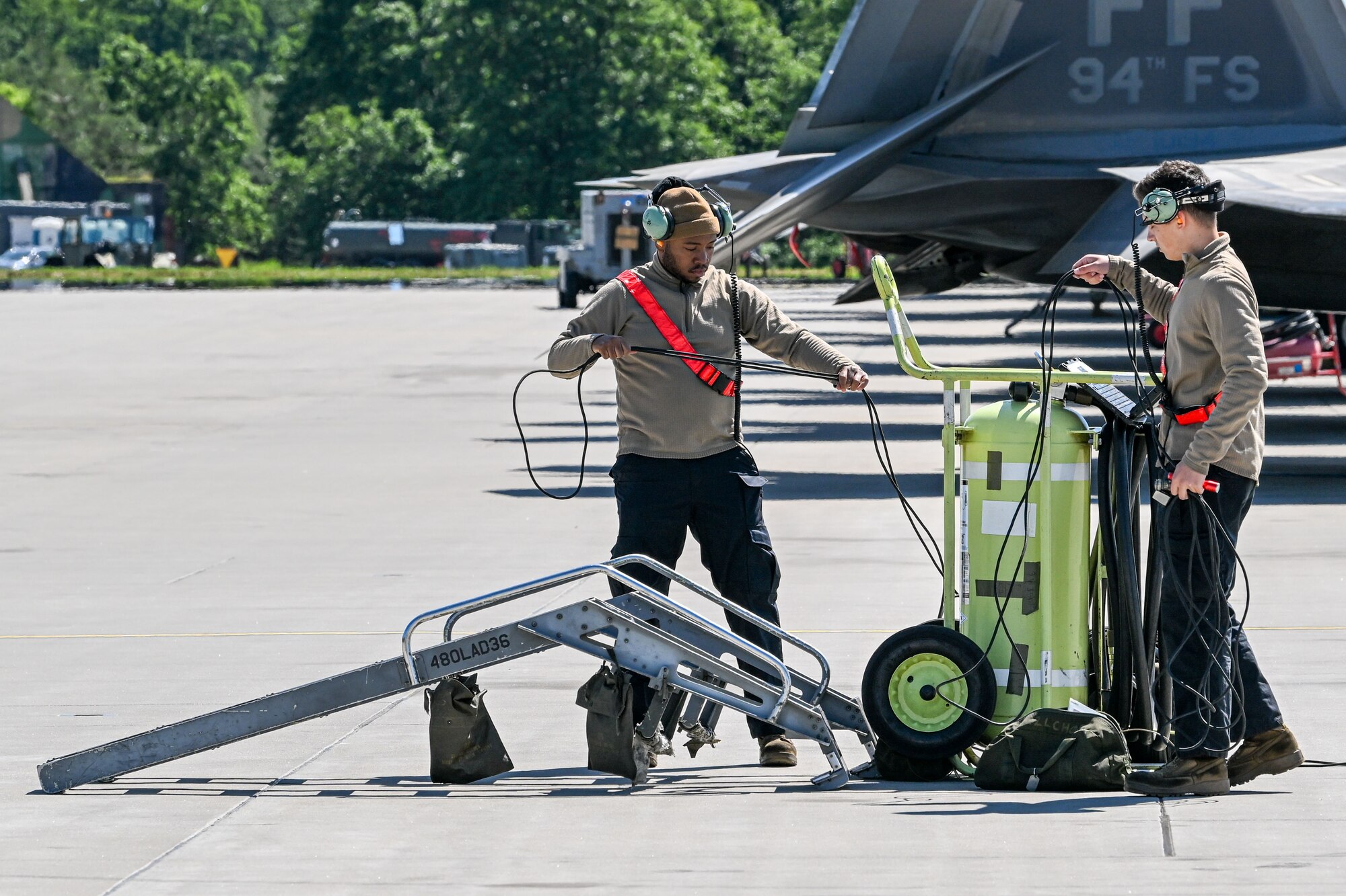 U.S. Airman 1st Class Jahvan Thom, 480th Fighter Generation Squadron crew chief, left, and Airman 1st Class Nestor Mendoza, 480th FGS crew chief, prepare for the arrival of aircraft