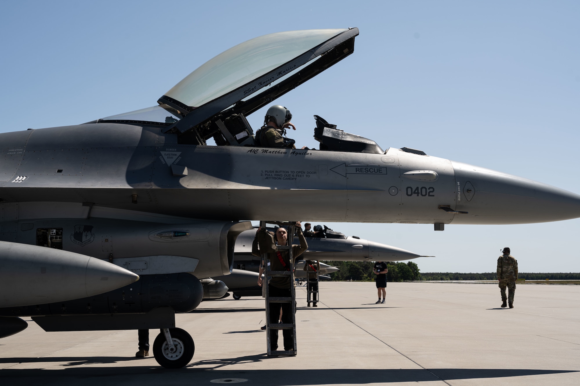 U.S. Air Force Senior Airman Rachel Reuber, 480th Fighter Generation Squadron crew chief, places a ladder for the pilot on an F-16 Fighting Falcon at Powidz Air Base, Poland