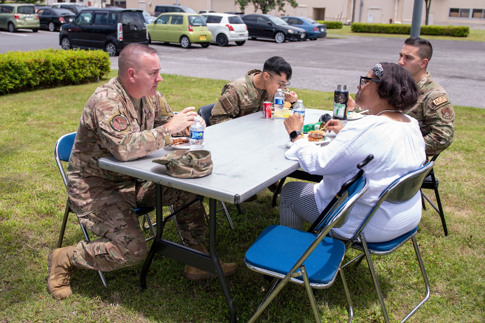 A man in a military uniform eats BBQ at a table with a civilian woman