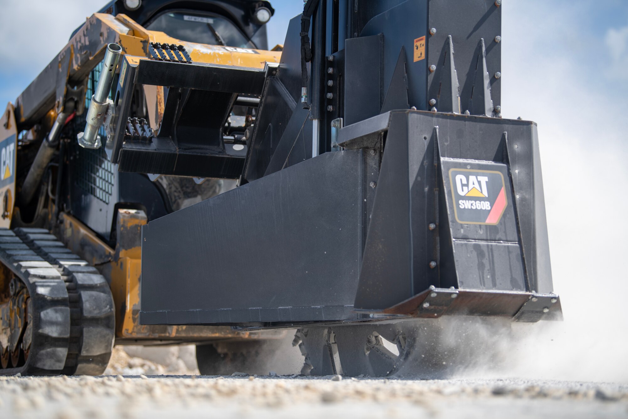 Skid-steer with concrete saw cutting up damaged airfield portion.