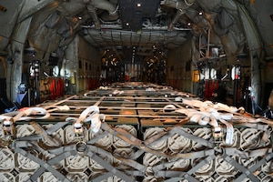A pallet of weapons is photographed inside a military aircraft.