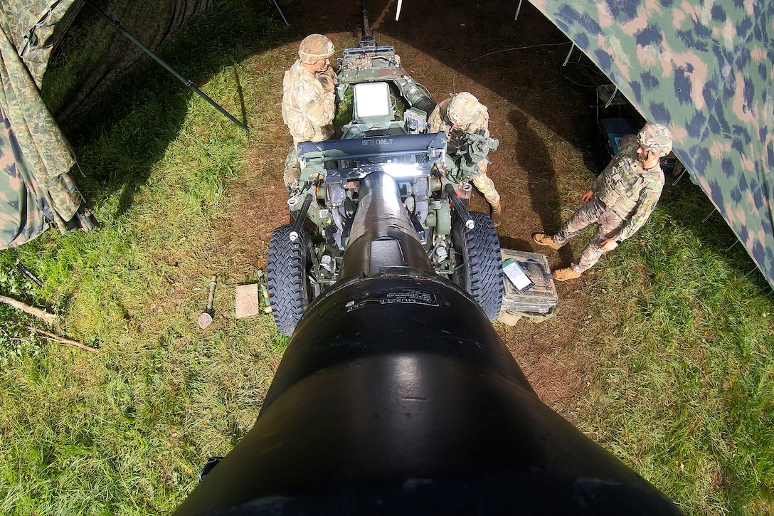 Soldiers set up a howitzer for fire during a training exercise.