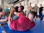 Tech Sgt. Onan Castro, top, and Master Sgt. Jordan Wiley, combative instructors of the 188th Security Forces Squadron, demonstrate defensive techniques during a training session June 8, 2023, at Ebbing Air National Guard Base in Arkansas. Security Forces Airmen refine their skills in hand-to-hand combat and grappling maneuvers to excel in close-quarters combat scenarios.