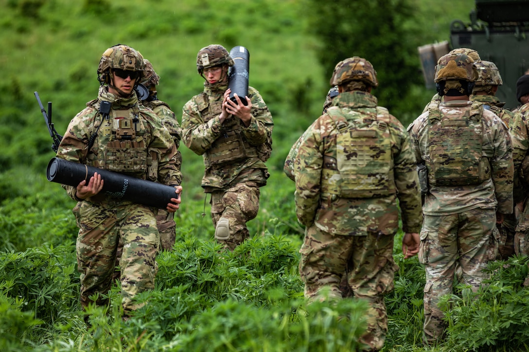 Soldiers carry mortar rounds during to the firing point during a training exercise.