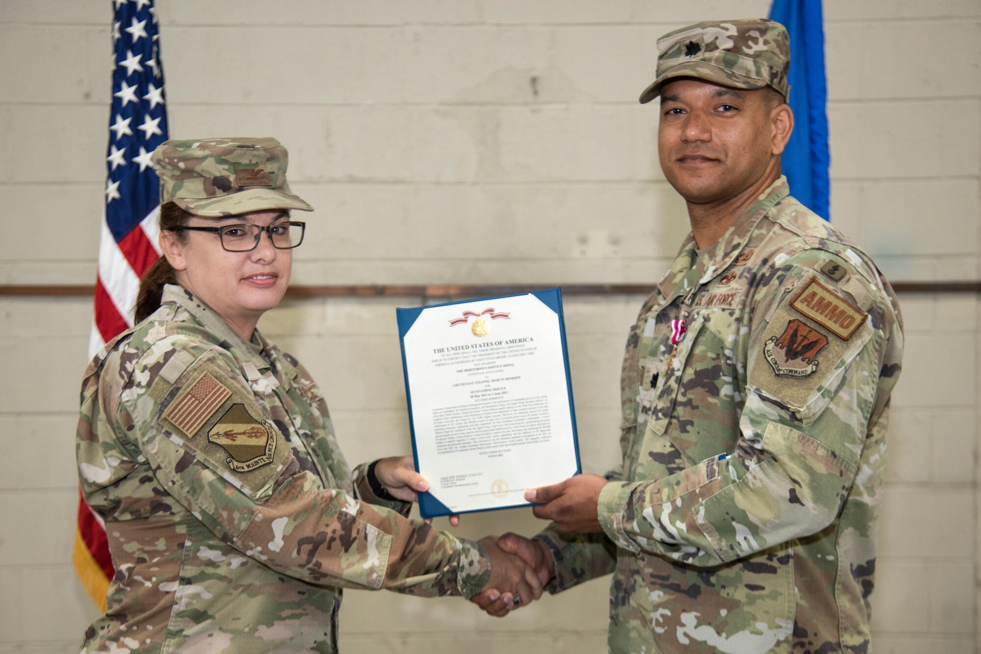 Col. Kathryn Roman, left, 4th Maintenance Group commander, awards the Meritorious Service Medal and certificate to Lt. Col. Marvin Hinkson, right, 4th Munitions Squadron outgoing commander, during the 4th MUNS change of command ceremony at Seymour Johnson Air Force Base, North Carolina, June 1, 2023. In keeping with tradition, the ceremony gave Hinkson chance to bid his Airmen farewell, and allowed Maj. James Phillips, 4th MUNS incoming commander, the opportunity to formally assume command of the squadron, meet the Airmen in his unit, and express his aspirations for the squadron’s future. (U.S. Air Force photo by Tech. Sgt. Christopher Hubenthal)
