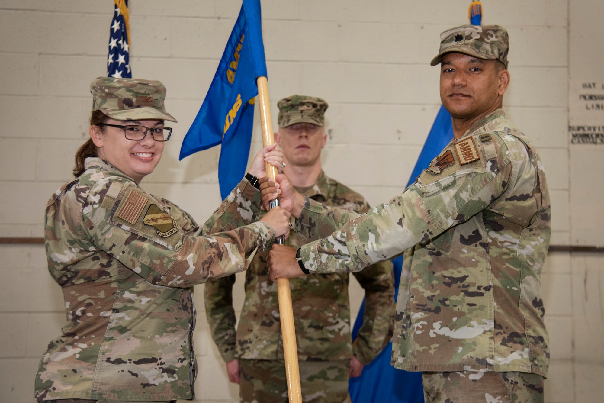 Lt. Col. Marvin Hinkson, right, 4th Munitions Squadron outgoing commander, relinquishes command of the 4th MUNS and passes the squadron’s guidon to Col. Kathryn Roman, 4th Maintenance Group commander, during the 4th MUNS change of command ceremony at Seymour Johnson Air Force Base, North Carolina, June 1, 2023. In keeping with tradition, the ceremony gave Hinkson a chance to bid his Airmen farewell, and allowed the incoming commander, Maj. James Phillips, the opportunity to formally assume command of the squadron, meet the Airmen in his unit, and express his aspirations for the squadron’s future. (U.S. Air Force photo by Tech. Sgt. Christopher Hubenthal)