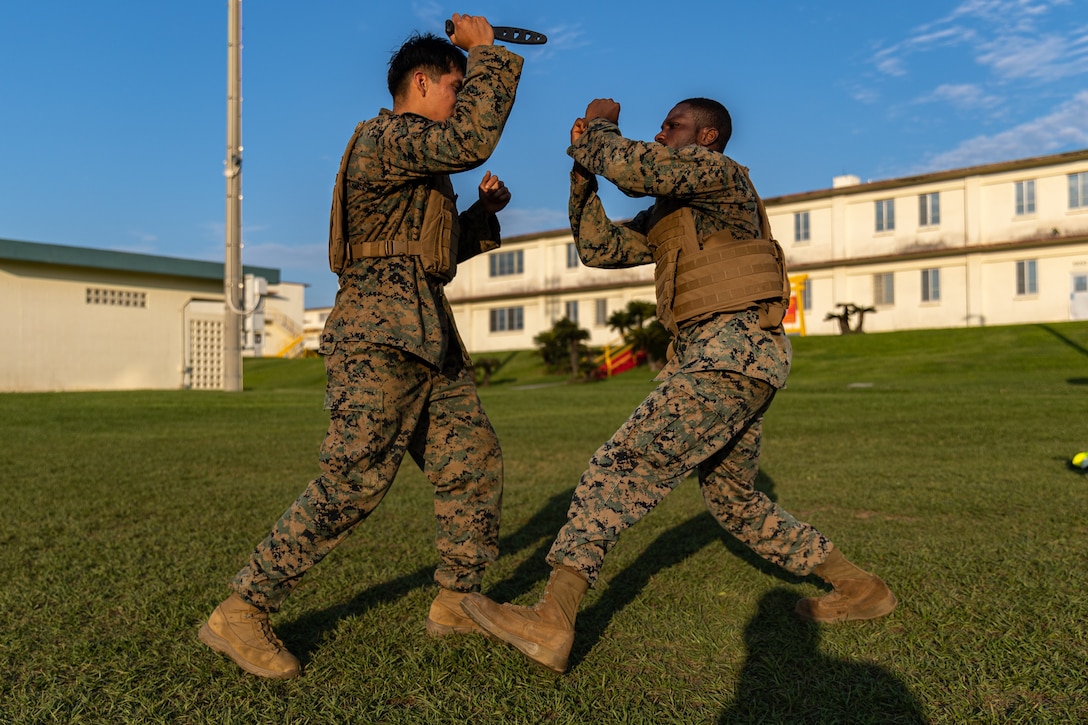U.S. Marine Corps Cpl. Alberto Gutierrez, left, a cryogenics equipment operator, and Cpl. Olayinka Okenmakinde, an aircraft maintenance support equipment electrician and refrigeration mechanic, both with Marine Wing Liaison Kadena, 1st Marine Aircraft Wing, perform knife techniques during a Marine Corps Martial Arts Program course on Camp Foster, Okinawa, Japan, May 11, 2023. MCMAP consists of combat conditioning, close-quarter and hand-to-hand combat techniques to ensure each Marine becomes a more effective war fighter.